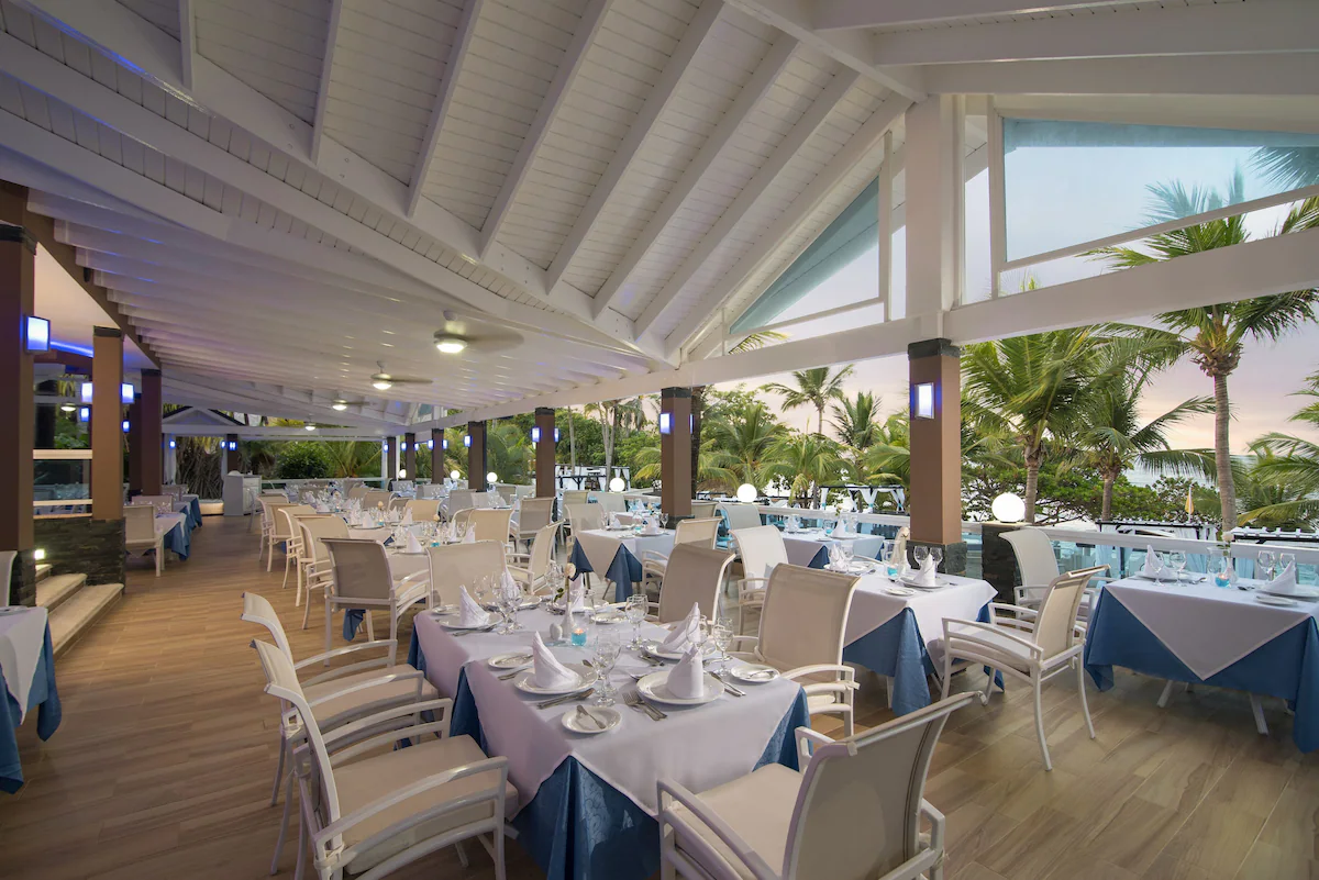 Open-air restaurant at sunset with palm trees